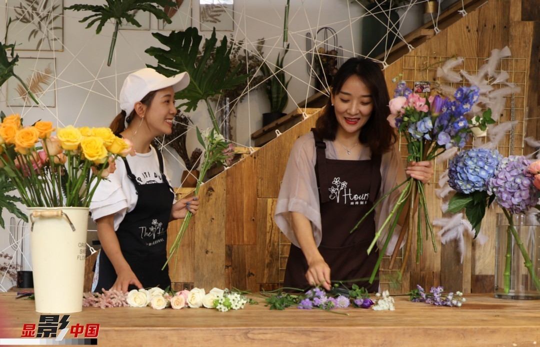 “昆明是鮮花的原產地，有亞洲最大的鮮切花交易市場，可以說具備開花店的天時地利；另外和很多女孩一樣，我從小也就有開花店的夢想！”說起當初的決定，王黎媛說一是因為夢想，另外也跟昆明這個城市產花、賣花的“基因”有關。圖為王黎媛和同事在制作花束。新華網 周亞平/攝 念新洪/文